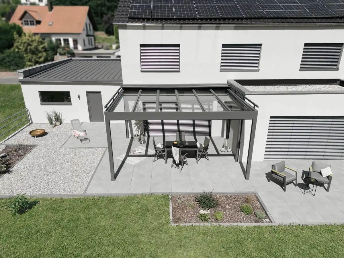 Terrassenüberdachung mit Solarpanelen Moderne Terrasse mit Überdachung und Solaranlage auf dem Dach eines Einfamilienhauses