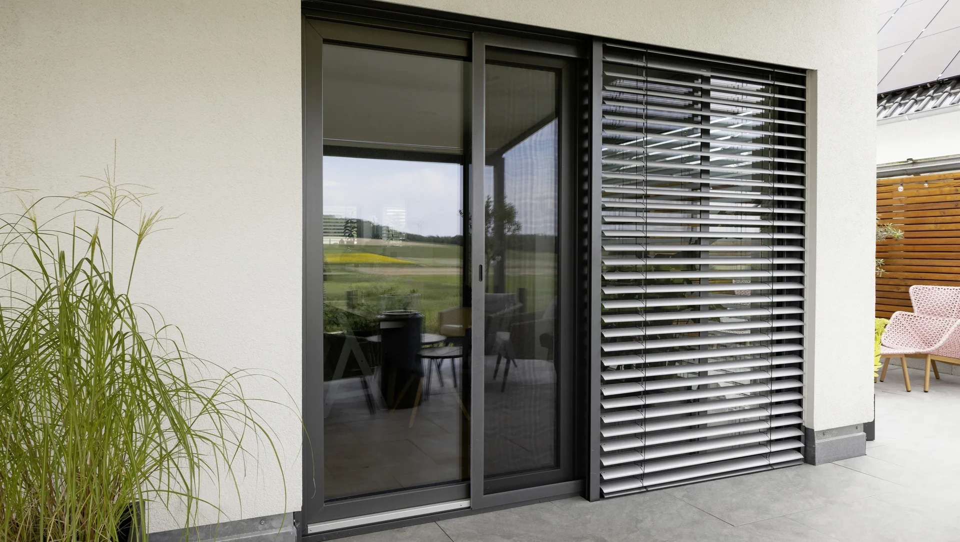 Moderne Terrassenverglasung mit Sonnenschutz und stilvoller Einrichtung