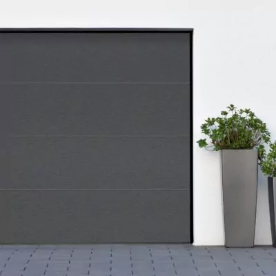 Modern gray garage, next to the Scandinavian-style house. Private garage with automatic door in a European city in Germany